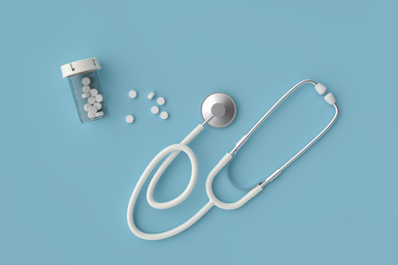 Stethoscope and pills in prescription bottle