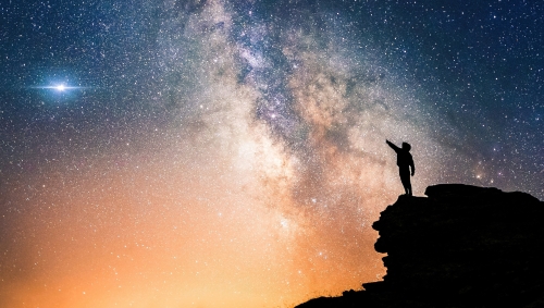 shutterstock-pol-sole-lone-person-standing-on-top-of-rock-pointing-with-hand-towards-the-milky-way.jpeg