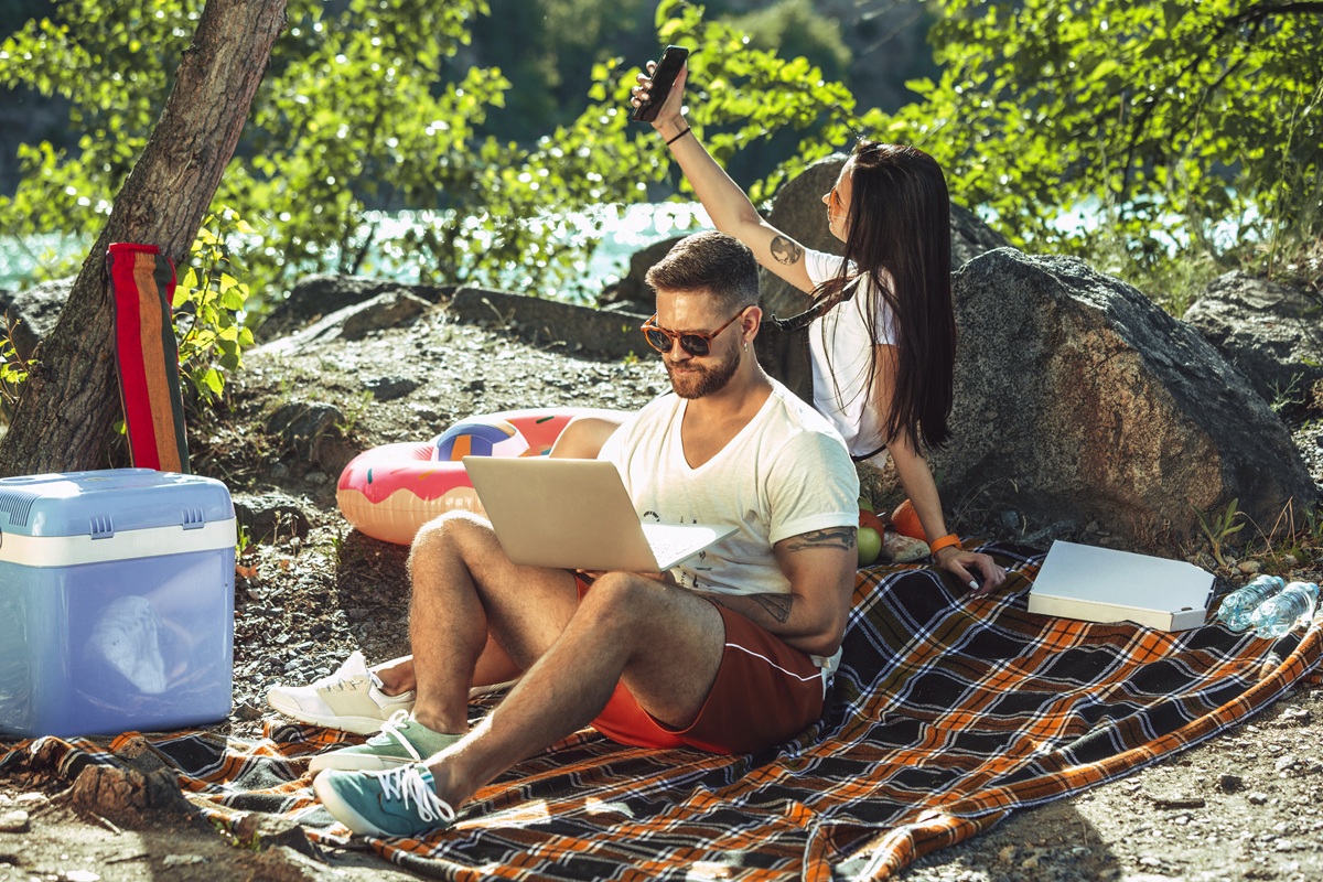 man-on-laptop-with-woman-taking-selfie-outdoors-2026-01-05-05-43-25-utc.jpg