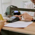 bank-teller-assisting-customer-behind-glass-partit-2026-01-09-10-58-40-utc-scaled.jpg