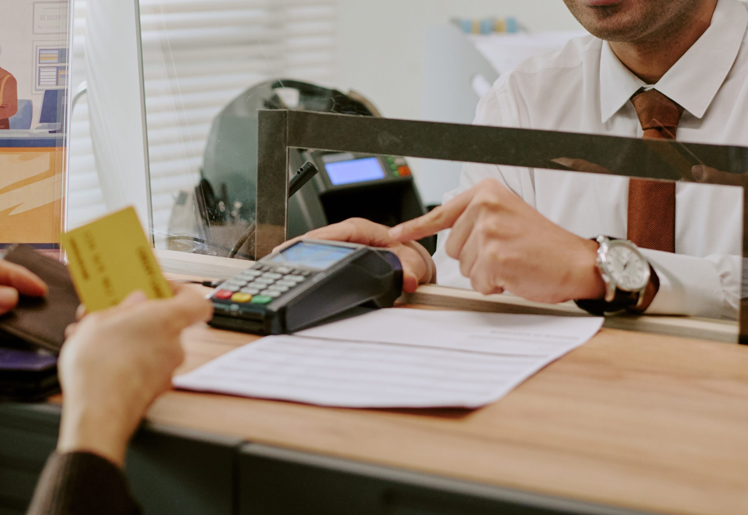 bank-teller-assisting-customer-behind-glass-partit-2026-01-09-10-58-40-utc-scaled.jpg