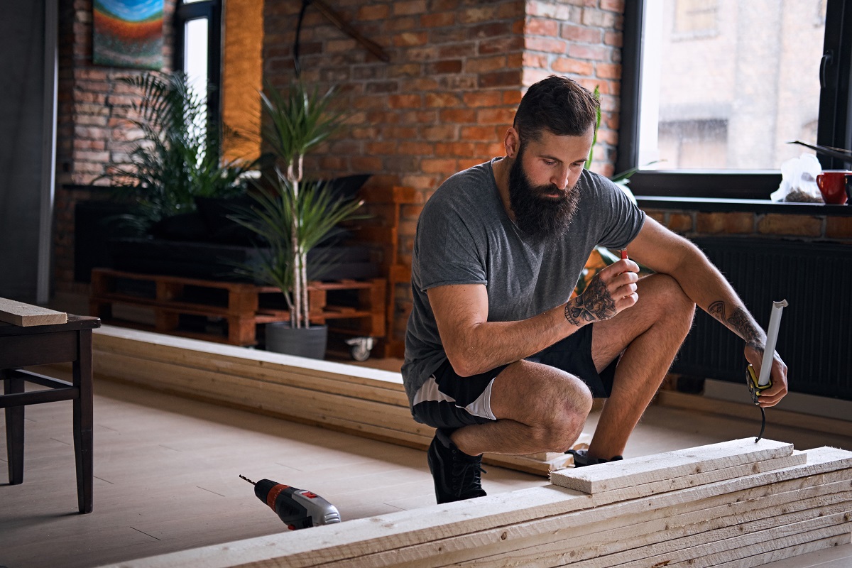 carpenter-measuring-boards-in-a-room-with-loft-int-2025-01-25-01-26-27-utc.jpg